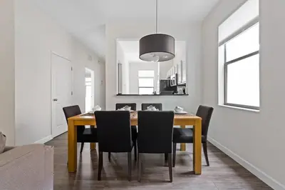 a dining room with a wooden table and black chairs at 4 BR Hot Tub Cozy Decor @ Regal Oaks RO2761N in Kissimmee