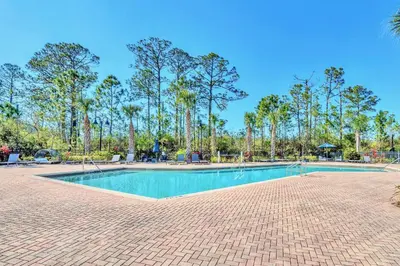 a swimming pool in a park with palm trees at Near Disney - 3BR Condo - Pool and Games in Orlando
