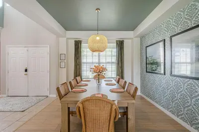 a dining room with a wooden table and chairs at 8575 - 7th Heaven Villa in Kissimmee