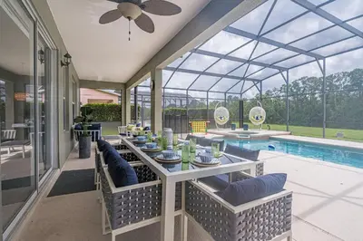 a dining room with a table and a swimming pool at 8575 - 7th Heaven Villa in Kissimmee