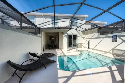 a house with a swimming pool and two black chairs at Themed 4BR Home-Mickey & Star Wars Pool Spacious in Kissimmee