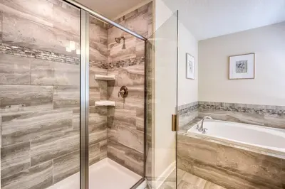 a bathroom with a tub and a glass shower at Stunning Home Private Pool Great Location in Kissimmee