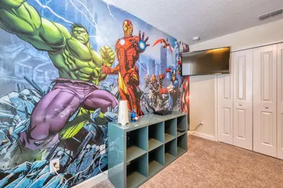 a room with a marvel mural on the wall at Stunning Home Private Pool Great Location in Kissimmee