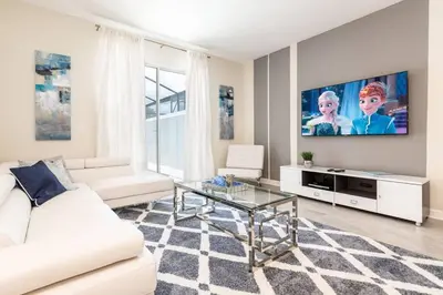 a living room with a white couch and a tv at Best Vacation Villa, Themed Beds, Private Pool in Kissimmee