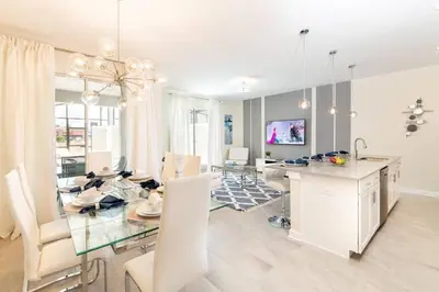 a dining room with a glass table and white chairs at Best Vacation Villa, Themed Beds, Private Pool in Kissimmee