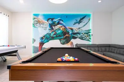 a pool table in a living room with a painting at Modern Marvel-Spacious, Themed, Fun-Filled in Kissimmee