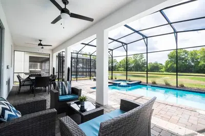 a living room with a swimming pool with a ceiling fan at Modern Marvel-Spacious, Themed, Fun-Filled in Kissimmee
