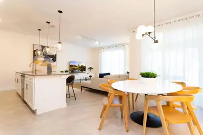 a kitchen and living room with a table and chairs at Chic Modern Marvel, Themed Beds, Private Pool in Kissimmee
