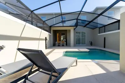 a swimming pool with a chair next to a house at Chic Modern Marvel, Themed Beds, Private Pool in Kissimmee