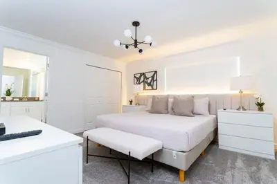 a white bedroom with a bed and a desk at Chic Modern Marvel, Themed Beds, Private Pool in Kissimmee