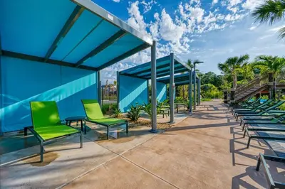 a group of green chairs and a blue building at Chic Modern Marvel, Themed Beds, Private Pool in Kissimmee