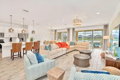 a living room with a couch and a kitchen at Upstay Lakeside 10 Bedroom Home with Pool Private Cinema & Game Room in Kissimmee