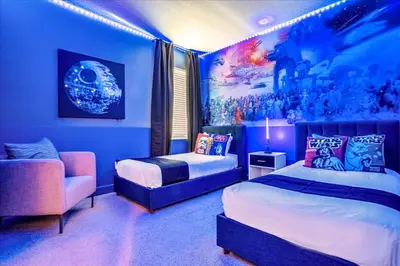 a blue bedroom with two beds and a couch at Upstay Lakeside 10 Bedroom Home with Pool Private Cinema & Game Room in Kissimmee