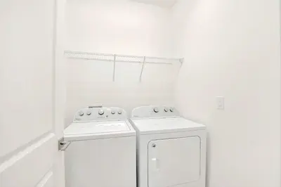 a white kitchen with a stove and a refrigerator at Upstay Lakeside 10 Bedroom Home with Pool Private Cinema & Game Room in Kissimmee