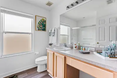 a white bathroom with a sink and a toilet at 5BR Themed Pool Home Near Disney World in Kissimmee