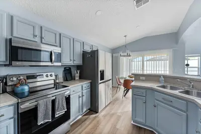 a kitchen with white cabinets and a black appliances at 5BR Themed Pool Home Near Disney World in Kissimmee