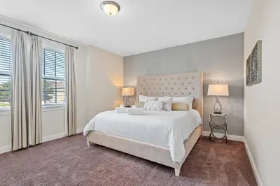 a bedroom with a large white bed with two lamps at 8 Bd home with Themed rooms and Pool 2308 in Orlando