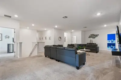 a living room with a blue couch and a table at Spacious Family Reunion 15BR Home Pool Spa Game Rm in Kissimmee