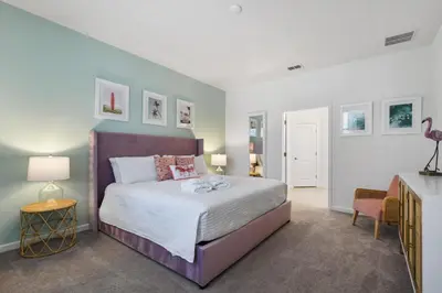 a bedroom with a bed and two tables and two lamps at Spacious Family Reunion 15BR Home Pool Spa Game Rm in Kissimmee