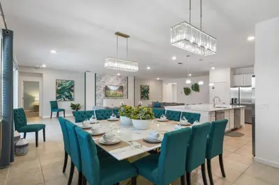 a dining room and kitchen with a table and chairs at Spacious Family Reunion 15BR Home Pool Spa Game Rm in Kissimmee