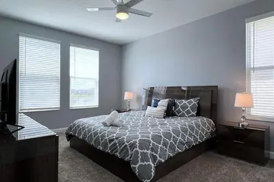 a bedroom with a bed and a ceiling fan at Disney World-House Up to 18 ppl at Storey Lake-Cloud9 in Kissimmee