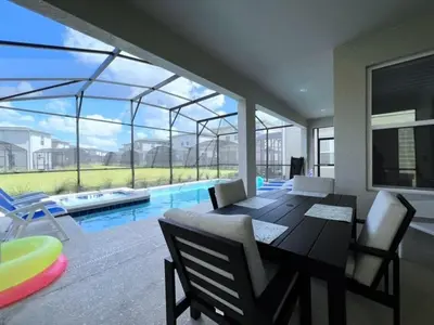 a dining room with a table and chairs and a pool at Disney World-House Up to 18 ppl at Storey Lake-Cloud9 in Kissimmee