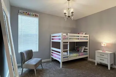 a bedroom with a white bunk bed and a chair at Disney World-House Up to 18 ppl at Storey Lake-Cloud9 in Kissimmee