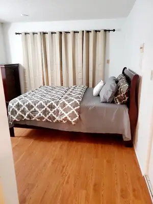 a bed in a room with a wooden floor at The Farm House in Sanford