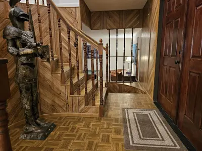 a hallway with a wooden staircase with wooden floors at The Farm House in Sanford