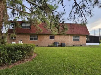 a brick house with a green lawn in front of it at The Farm House in Sanford