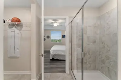 a bathroom with a walk in shower next to a glass door at Storey Lake: Apartment with lake view in Kissimmee