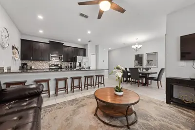 a living room and kitchen with a couch and a table at Home with a pool at Storey Lake Resort in Kissimmee