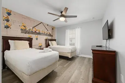 a bedroom with two beds and a flat screen tv at Home with a pool at Storey Lake Resort in Kissimmee