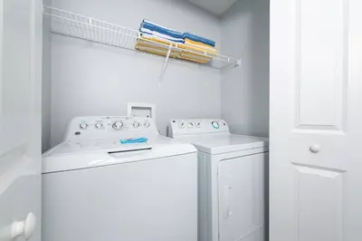 a white laundry room with a washer and dryer at Home with a pool at Storey Lake Resort in Kissimmee