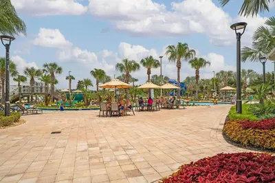 a patio with tables and umbrellas at a resort at Home with a pool at Storey Lake Resort in Kissimmee