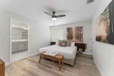 a white bedroom with a bed and a table at Townhome with pool at Storey Lake in Kissimmee