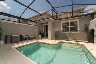 a swimming pool in front of a house at Townhome with pool at Storey Lake in Kissimmee
