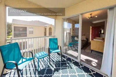a balcony with two chairs and a view of a room at Stunning 3BD Condo 14 Mins to Disney World , Gated in Kissimmee