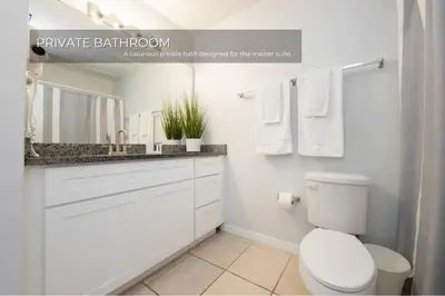 a white bathroom with a toilet and a sink at Stunning 3BD Condo 14 Mins to Disney World , Gated in Kissimmee