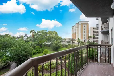 a balcony with a view of a park and buildings at Apartment with Volcano Bay view in Orlando