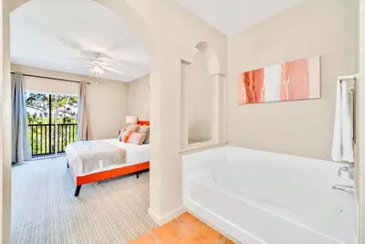 a white bathroom with a bed and a tub at Modern 2BR Condo - Pool - Near Disney in Orlando