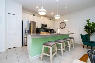 a kitchen with a green counter and bar stools at Vibrant Themed Home Prime Location in Kissimmee