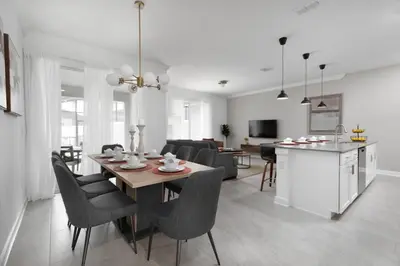a kitchen and living room with a table and chairs at Modern Chic-Spacious, Private Pool, Prime Location in Kissimmee