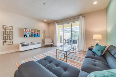 a living room with a blue couch and a table at Cozy Villa Private Pool Prime Spot in Orlando