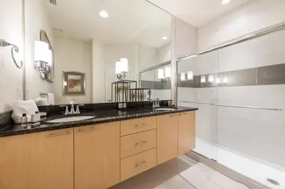 a bathroom with two sinks and a glass shower at Spacious Comfortable Perfect Vacation in Orlando