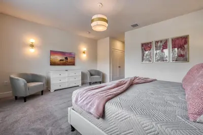 a bedroom with a bed and two chairs and a dresser at Modern Luxury Retreat - Mickey & Harry Potter Beds in Orlando