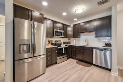 a kitchen with stainless steel appliances and wooden cabinets at Leisure & Business Oasis-Near Convention Center in Orlando