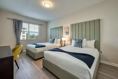a hotel room with two beds and a chair at Leisure & Business Oasis-Near Convention Center in Orlando