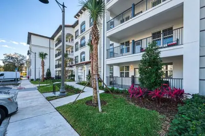a apartment building with palm trees and a sidewalk at Leisure & Business Oasis-Near Convention Center in Orlando
