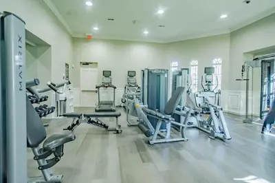 a gym with several treadmills and cardio machines at Central Elegance-Spacious Beautifully Decor Condo in Orlando